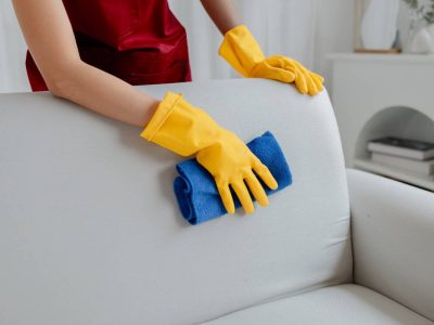Female cleaning staff, housekeeper cleaning the sofas in the company office, maintaining cleanliness in the office. Cleaning concept and housekeeper taking care of cleanliness and order in the office.