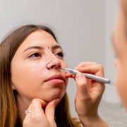 close-up plastic surgeon makes marks on a patient's face during a consultation before nose operation