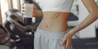 A beautiful girl standing in a gym with bottle of water
