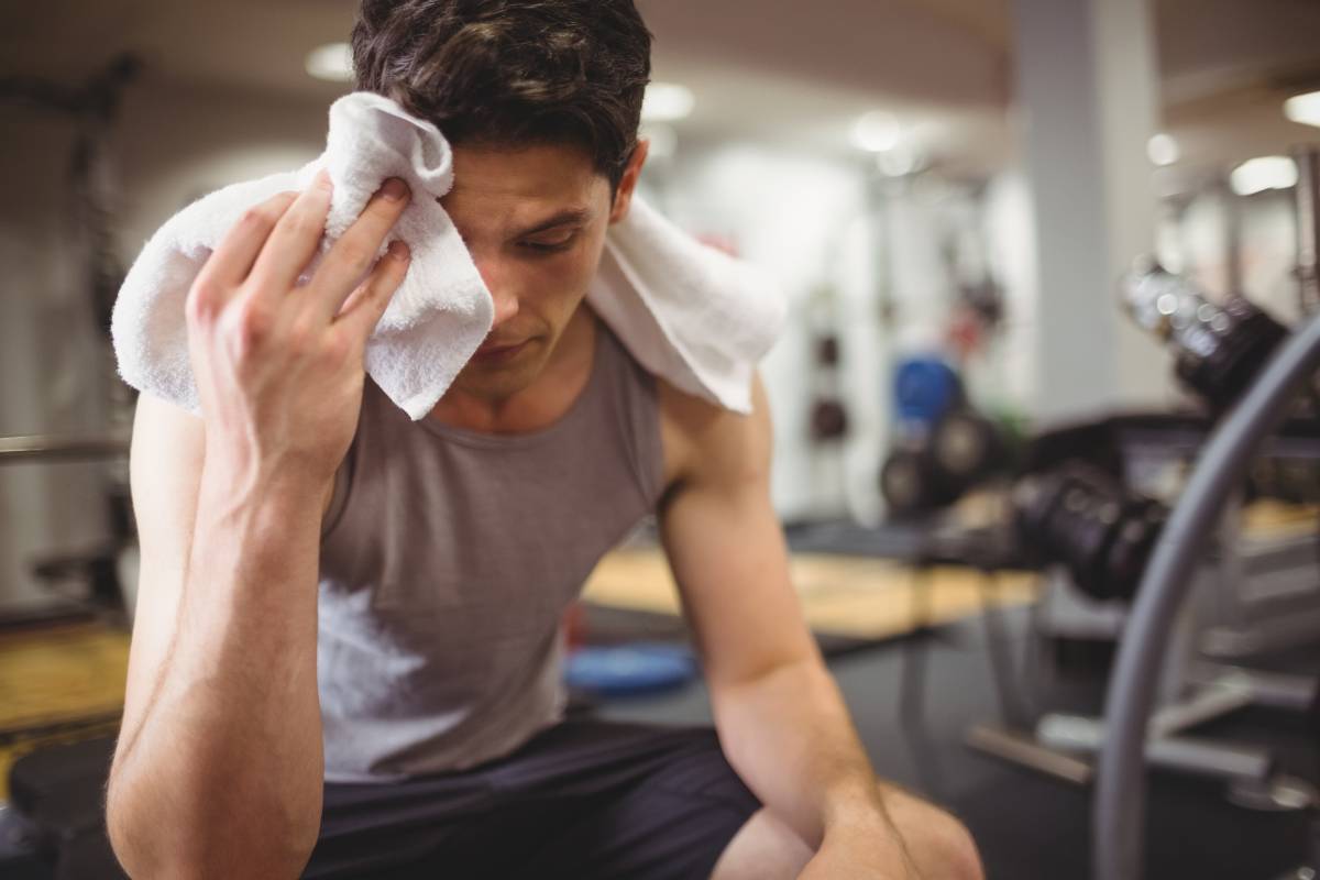 Fit man taking a break from working out at the gym